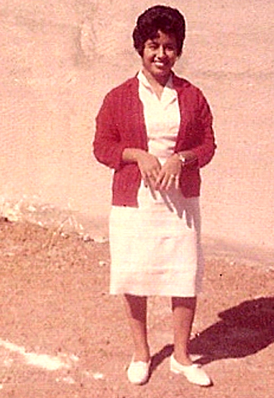 Molly O. Anthony at age 17 in 1960 standing near the school building.